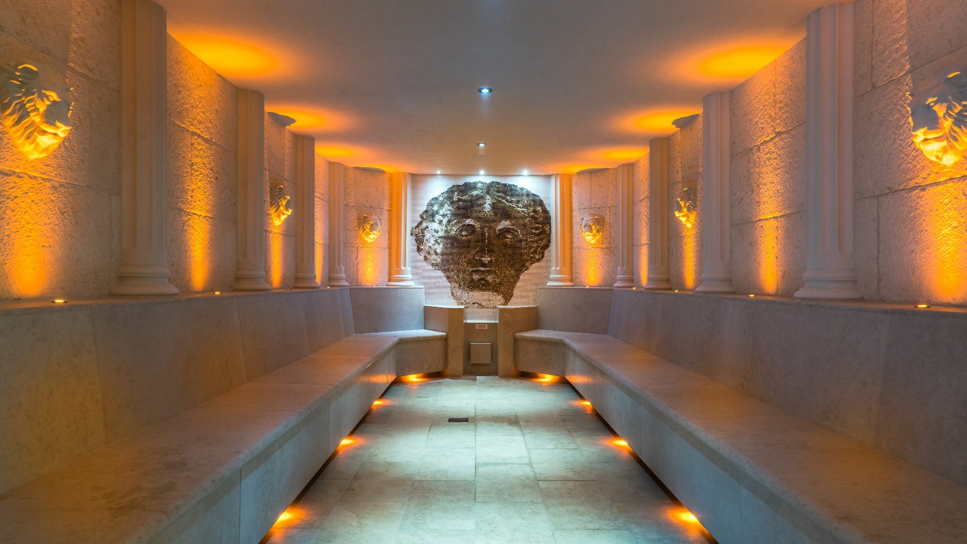 Luxury thermal suite at Thermae Bath Spa featuring heated stone seating, ambient lighting and bespoke wellness design.